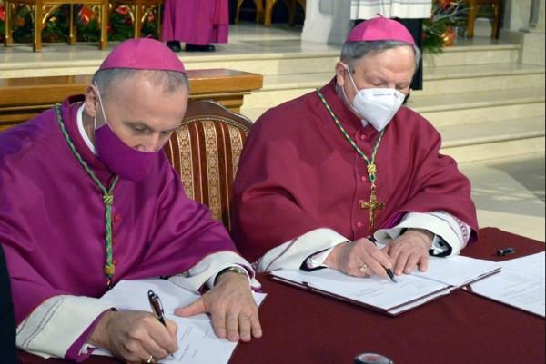 Jako pierwsi dokumenty podpisali: ustępujący bp Henryk Tomasik (z prawej) i nowy ordynariusz bp Mare