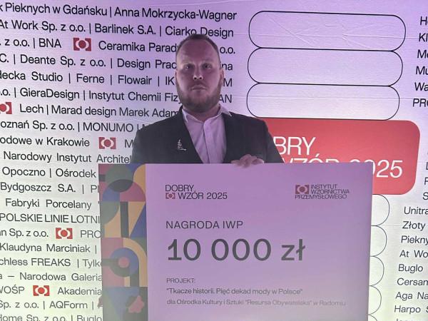 Kurator wystawy, Przemysław Zieliński, z nagrodą